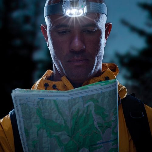Peli headlamp used at night by a man to read a map.